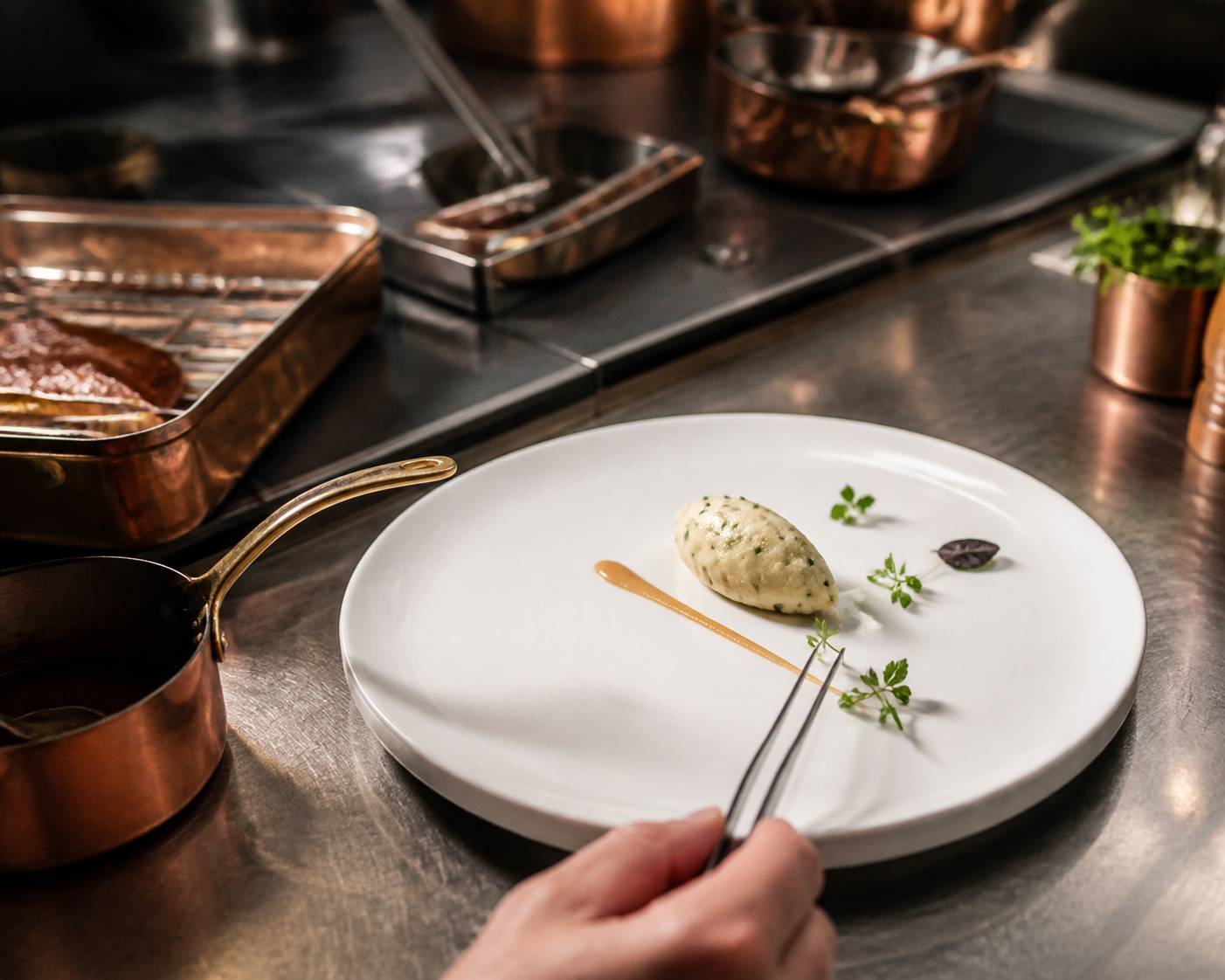Assiette gastronomique en cours de dressage avec pince